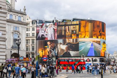 Piccadilly Sirki 'nde canlı dijital reklam panoları, kırmızı bir otobüs ve kalabalık var. Londra, İngiltere, 16 Temmuz 2023