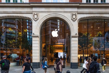 Londra 'daki Apple Store' da önemli bir logo, cam pencereler ve hareketli bir sokak ortamı yer alıyor. Londra, İngiltere, 19 Ağustos 2023