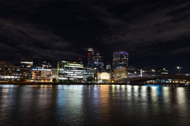 Londra geceleri gökyüzü, Thames nehrine yansıyan aydınlık binalarla aydınlanır.