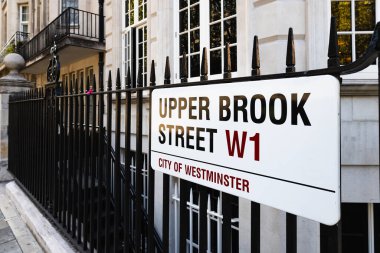Londra, Mayfair 'deki Upper Brook Caddesi tabelası, etrafı demir parmaklıklarla çevrili.