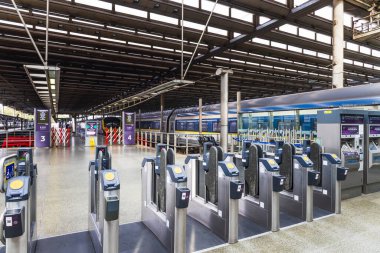 Parlak doğal ışıklandırması ve geniş platformları olan lüks bir tren istasyonunda otomatik bilet engelleri. Londra, İngiltere, 1 Ekim 2023