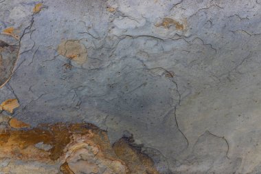 Gri taş dokusuyla soyut çatlak yüzey, yıpranmış ayrıntıları bir makroda yakından göstererek, sıkıntılı bir deseni ortaya çıkarıyor.