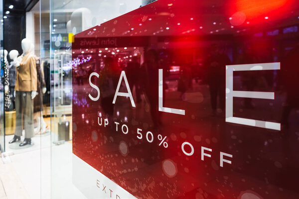 Яркий красный знак продажи отображается на витрине магазина рекламные скидки до 50 процентов