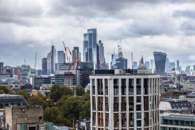 Londra şehir manzarası, yüksek binalar ve finansal bölge üzerinde bulutlu gökyüzü. Londra, İngiltere, 21 Ekim 2023