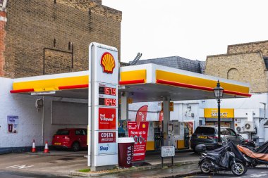 Kabuk benzinci manzarası kalabalık bir sokak köşesi gösteriyor, arabalar ve motosikletlerle. Londra, İngiltere, 28 Ekim 2023