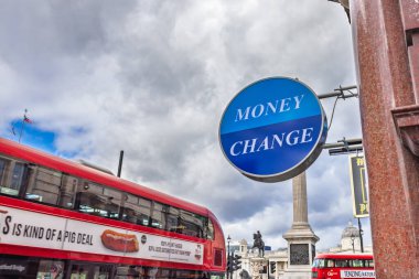 Para üstü tabelası ve işlek caddede kırmızı Londra otobüsü olan döviz kuru dükkanı. Londra, İngiltere, 5 Kasım 2023