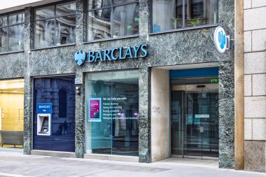 Barclays Bank şubesinin dış görünüşü ATM, cam cephe ve kalabalık bir kentsel alanda tabela ile. Londra, İngiltere, 5 Kasım 2023