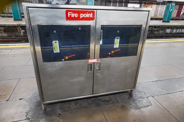 Yangın noktası güvenlik dolabı Londra metro platformunda acil durum yangın ekipmanları için.