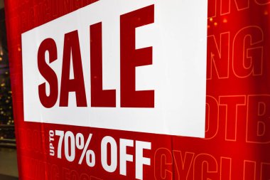Sezonluk satış promosyonu sırasında mağaza vitrininde% 70 indirim gösteren parlak kırmızı yazı.