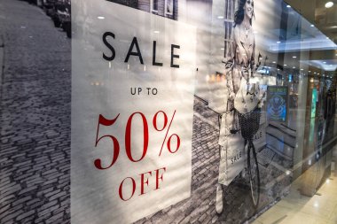 Mevsimlik bir alışveriş promosyonu sırasında yüzde 50 indirimli tabela içeren moda mağazası vitrinleri. Londra, İngiltere, 24 Aralık 2023