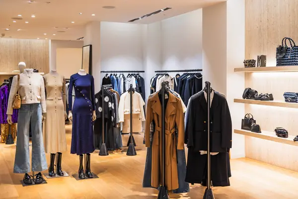 Şık ceketli, elbiseli ve mankenli aksesuarlı lüks giyim mağazası. Londra, İngiltere, 24 Aralık 2023
