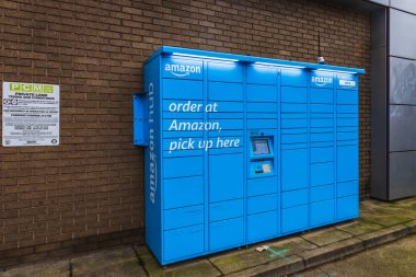 Güvenli paket koleksiyonu ve teslimatı için mavili Amazon Dolapları. Londra, İngiltere, 25 Aralık 2023