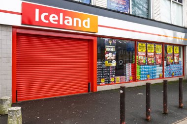 Cesur kırmızı kepenkleri ve satış vitrinleri olan İzlanda İngiltere süpermarketi. Londra, İngiltere, 25 Aralık 2023