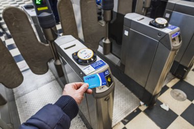 Londra metro kapısından girmek için Oyster kartını tarayan yolcular. Londra, İngiltere, 31 Aralık 2023