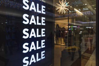 Alışveriş merkezinin vitrininde müşterileri çeken sürekli indirimli tabelalar var. Londra, İngiltere, 31 Aralık 2023