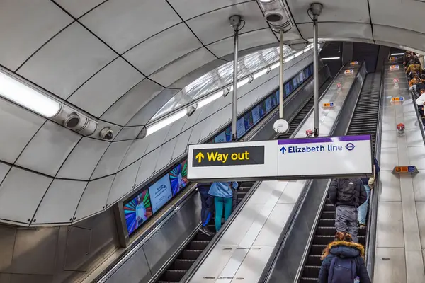 Metro içi yolcuları ve istasyon çıkışına giden işareti gösteriyor. Londra, İngiltere, 31 Aralık 2023