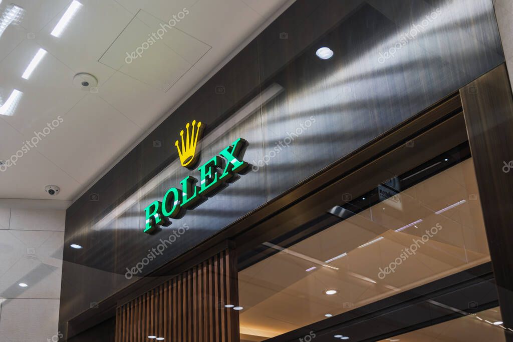 Rolex luxury watch store entrance with iconic crown logo signage inside a modern upscale shopping mall. London, UK, 10 February 2024