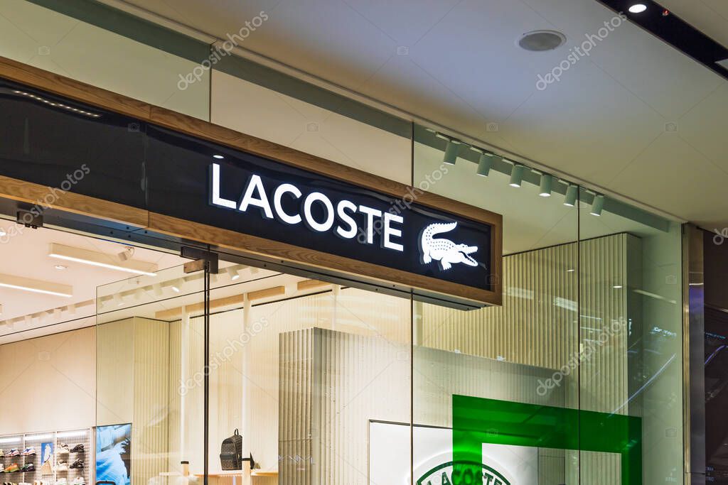 Lacoste clothing store entrance in a shopping mall, featuring the brand crocodile logo and sleek design. London, UK, 10 February 2024