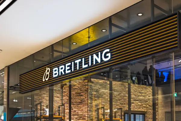 Pahalı bir alışveriş merkezinde parıldayan işaret ve cam cepheli bir butik mağazası. Londra, İngiltere, 10 Şubat 2024