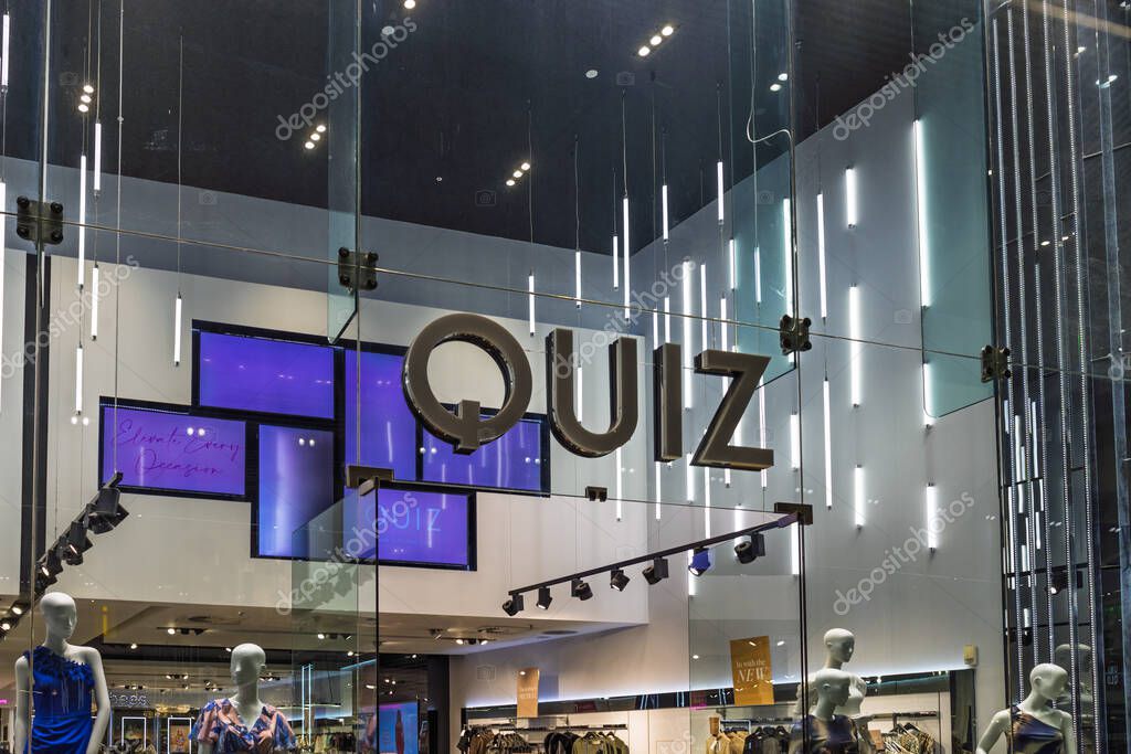 Quiz clothing store entrance with glowing signage, modern decor, and fashion forward branding in a mall. London, UK, 10 February 2024