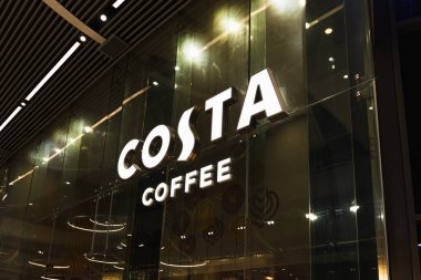 Parlak Costa Kahve tabelası parlıyor, şehir ortamında modern bir mağaza vitrini sergiliyor. Londra, İngiltere, 10 Şubat 2024