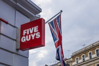 Şehir merkezindeki bir alışveriş merkezindeki ünlü hamburger zincirinin altını çizen şehir dışındaki bir binada açık kırmızı bir Beş Adam tabelası. Londra, İngiltere, 11 Şubat 2024