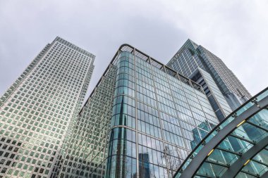 Canary Wharf işletme bölgesinde Londra 'nın finans merkezinde uzun cam ofis kuleleri ve şehir mimarisi sergileniyor. Londra, İngiltere, 17 Şubat 2024