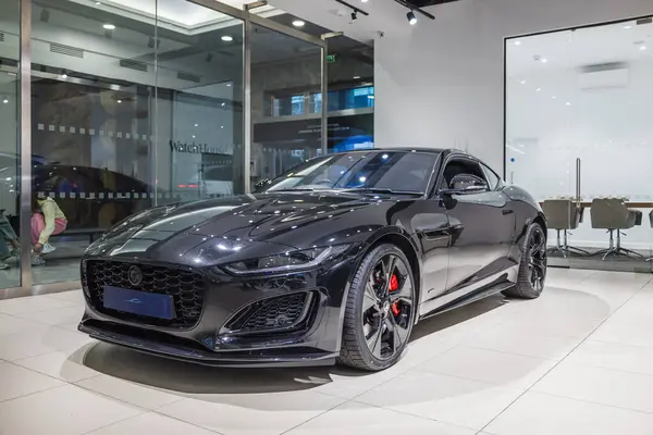Siyah Jaguar F-Type R-Dynamic Coupe 2024 modeli modern ışıklandırma ve premium modelleme ile kapalı alanda sergilenmektedir. Londra, İngiltere, 17 Şubat 2024