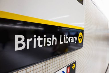 Siyah arkaplan üzerine koyu beyaz yazılı İngiliz Kütüphanesi tabelasına odaklanın, Londra ulusal kütüphanesinin girişini vurguluyor.