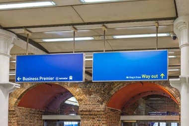 Mavi Eurostar geliş ve gidiş işaretleri tuğla duvarlı klasik tren istasyonunda. Londra, İngiltere, 25 Şubat 2024