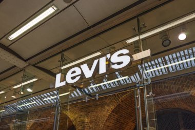Levis mağazasının dış cephesinde modern bir alışveriş merkezinin camında ışıklı logo var. Londra, İngiltere, 25 Şubat 2024