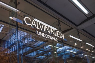 Calvin Klein mağazasının dış cephesinde lüks bir alışveriş merkezindeki cam üzerine aydınlatılmış logo var. Londra, İngiltere, 25 Şubat 2024