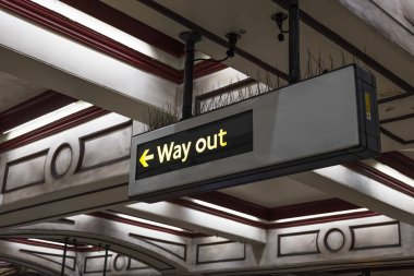 Aydınlatılmış Çıkış Yolu tarihi bir tren istasyonunun içindeki yolculara yol gösteren işaret levhası.
