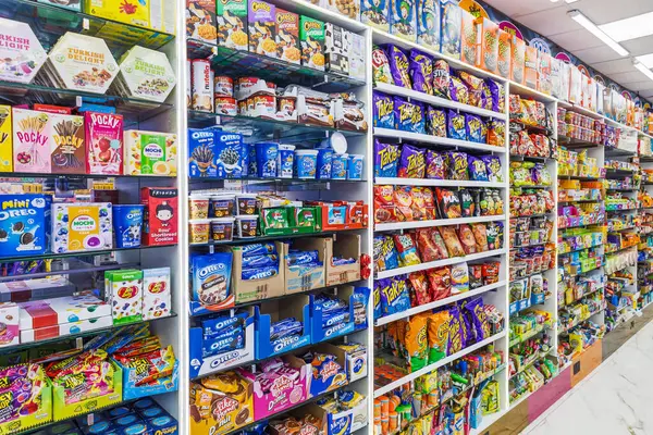 Market rafları çeşitli tatlı ikramlar, çikolatalar ve şeker paketleriyle dolu. Londra, İngiltere, 25 Şubat 2024