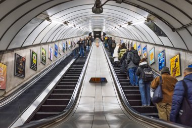 Londra metrosundaki yürüyen merdivenlerin iç görüntüsü. Yolcular iki yöne de gidiyor. Londra, İngiltere, 3 Mart 2024