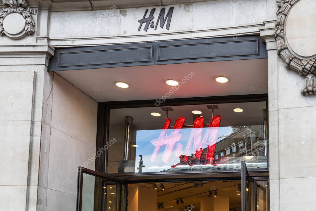 Exterior of H and M retail store with illuminated signage on urban shopping street facade. London, UK, 3 March 2024