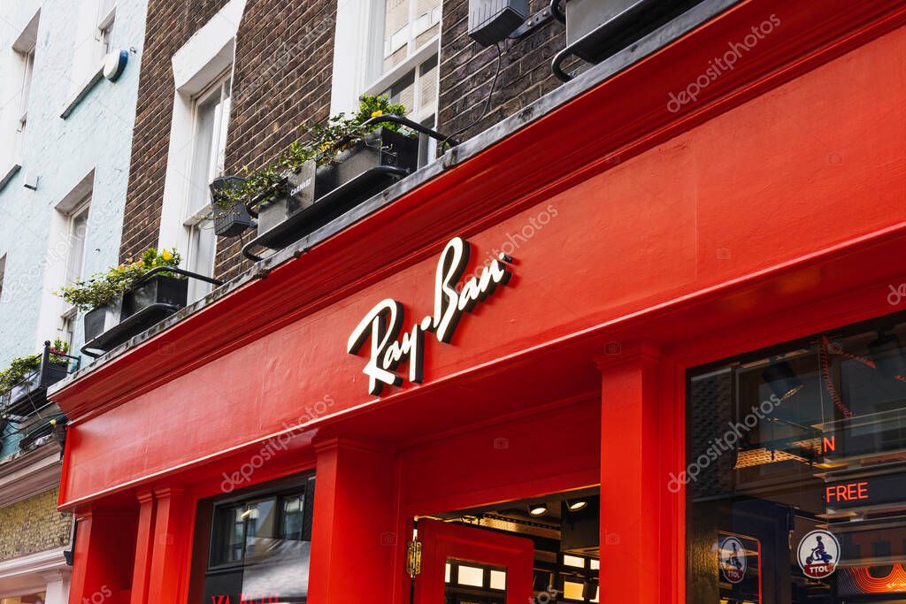 Exterior of Ray Ban retail store showcasing vibrant red signage in lively urban shopping district. London, UK, 3 March 2024
