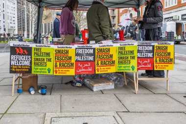 Barışçıl bir şehir gösterisinde ellerinde renkli pankartlar ve pankartlar tutan eylemcilerle sokak protestoları. Londra, İngiltere, 16 Mart 2024