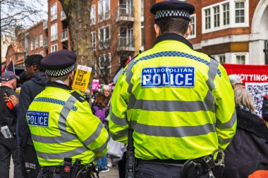 Kolluk kuvvetleri şehir gösterilerinde güvenliği görünür bir polis varlığıyla sağlıyor. Londra, İngiltere, 16 Mart 2024