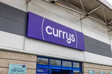 Perakende parkının girişinde koyu mavi-beyaz levhalı Currys mağazası var. Londra, İngiltere, 17 Mart 2024