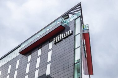 Hilton Oteli 'nin dış görünüşü modern cepheli ve inşaatta büyük bir logosu var. Londra, İngiltere, 17 Mart 2024