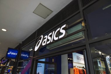 Asics 'in dış cephesinde parlak ışıklı tabela ve cam cephe var. Londra, İngiltere, 17 Mart 2024