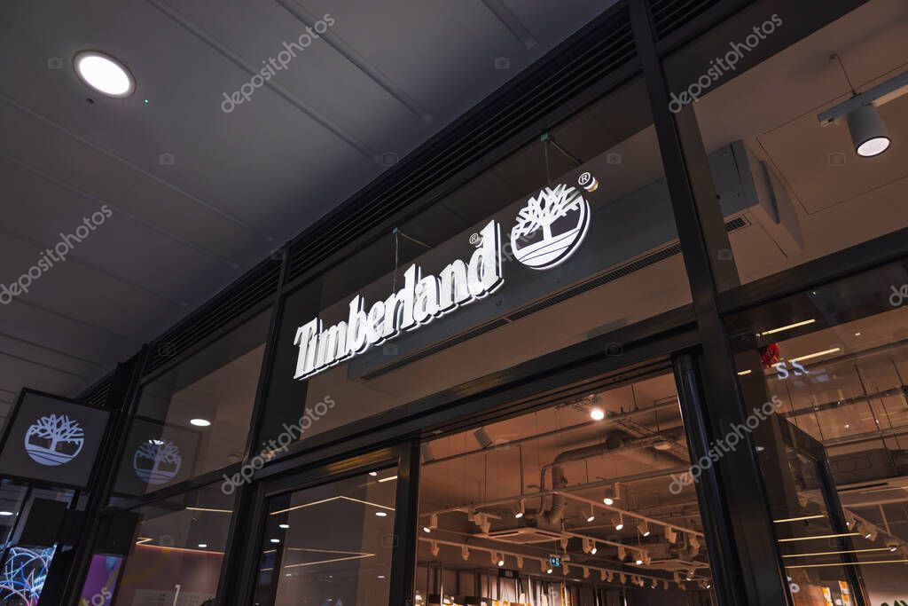 Timberland store exterior with bold illuminated logo and glass storefront in mall. London, UK, 17 March 2024