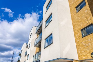 Canlı gökyüzüne ve dağınık bulutlara karşı modern mimariye sahip kentsel daireler..