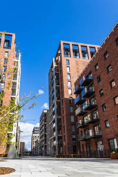 Yüksek kırmızı tuğlalı binaları ve temiz bir caddede güneşli havası olan kentsel yerleşim yerleri..