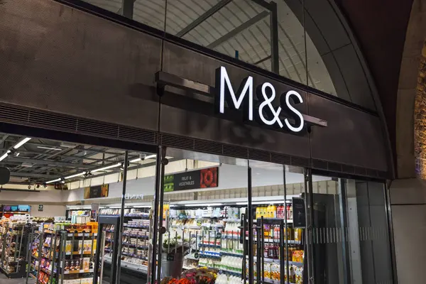 Parlak Marks ve Spencer logosunun yer aldığı modern perakende mağazası içerideki müşterileri karşılıyor. Londra, İngiltere, 29 Mart 2024