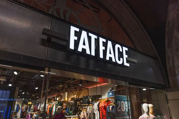 Giriş kapısının üstündeki ışıklı FatFace tabelasında popüler İngiliz yaşam tarzı giyim markası var. Londra, İngiltere, 29 Mart 2024