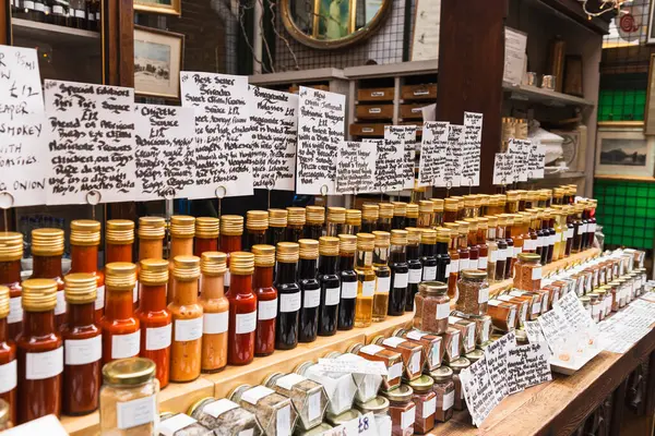 Borough Market 'te düzenlenmiş geniş bir baharat ve bal kavanozu seçimi. Londra, İngiltere, 29 Mart 2024