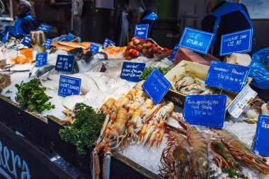 Gurme deniz ürünleri çeşitliliği popüler Borough Market gıda pazarında cazip bir şekilde düzenlendi. Londra, İngiltere, 29 Mart 2024