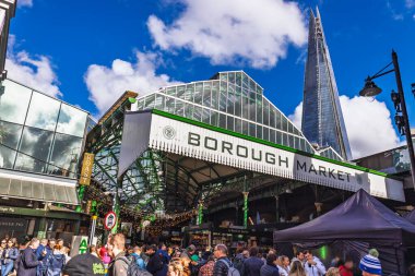 Iconic Borough Market girişi Londra 'nın gıda merkezinde aydınlık bir günde ziyaretçilerle doluydu. Londra, İngiltere, 29 Mart 2024